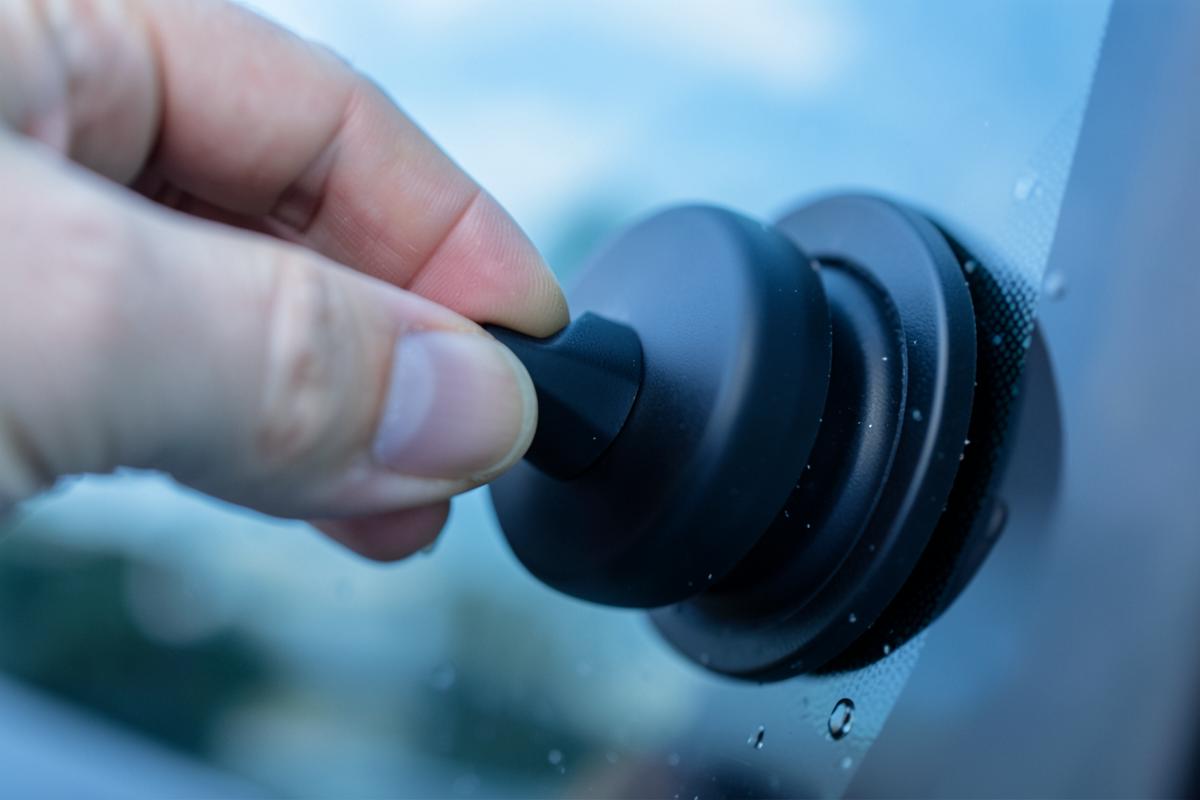 Doigt actionnant le piston de la pompe à vide du support fixé sur le pare-brise